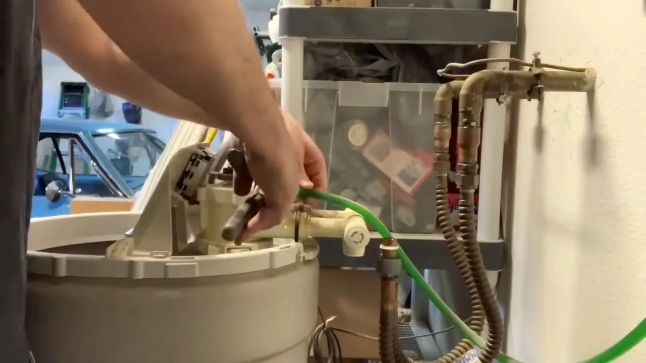 Close view of hand removing water softener control valve handled during a choosing a filtration system appointment