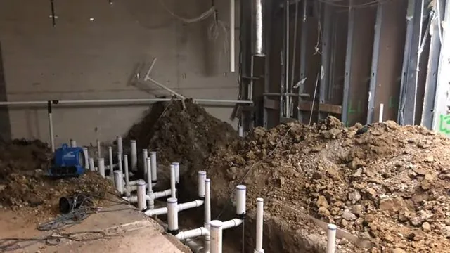 A technician working on commercial restroom trenches and drain stubs during a commercial maintenance schedule call near Chapel Hill