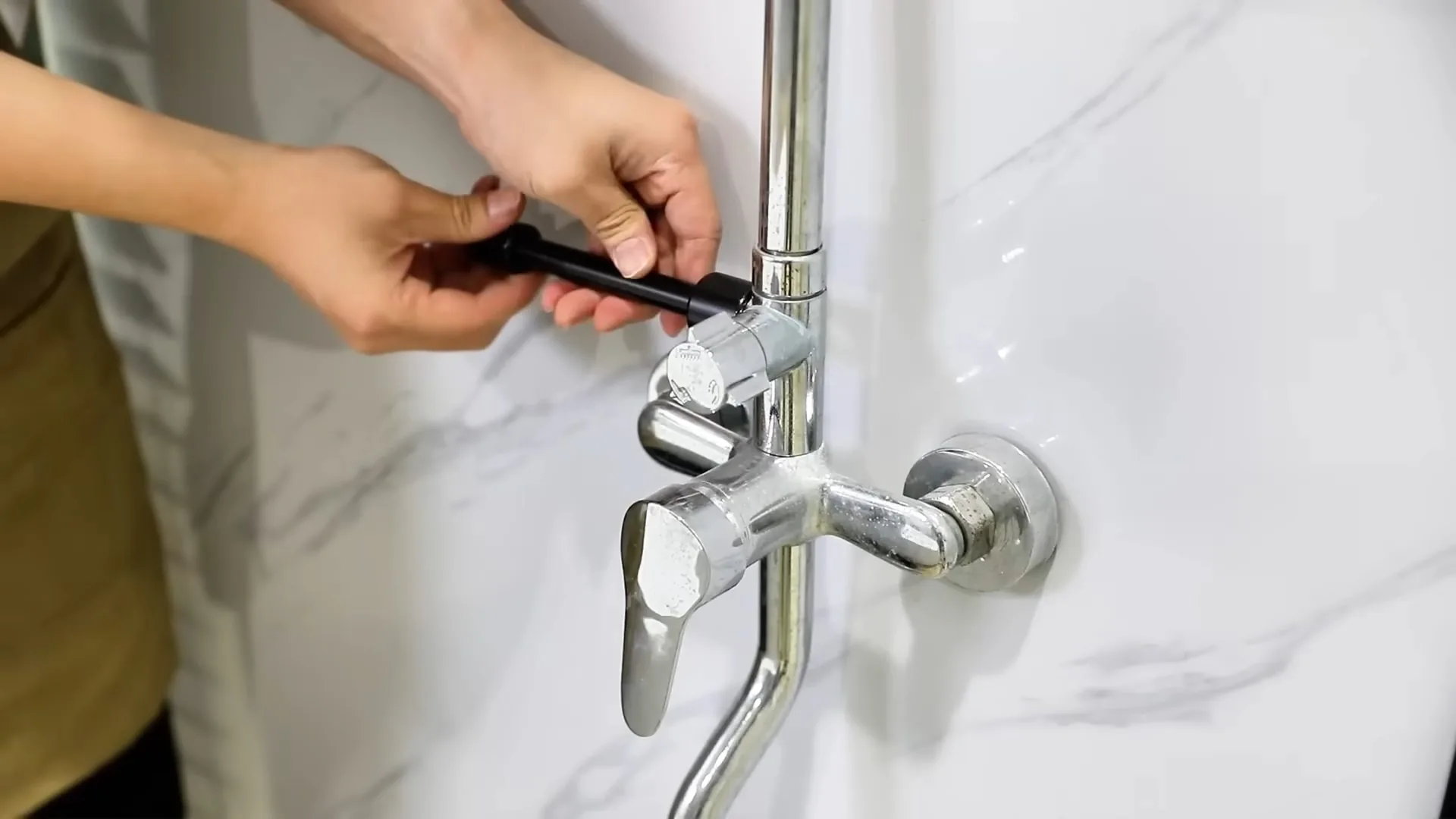 Hand demonstrating wall mount faucet photographed on site during dripping faucet causes work