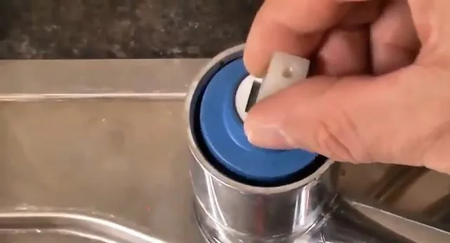 Close view of lifting cartridge cap from kitchen faucet handled during a low water pressure causes appointment