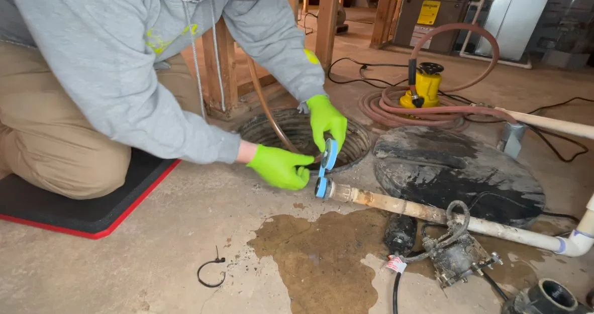 A look at worker replacing sump pump in basin from a recent preventing frozen pipes visit