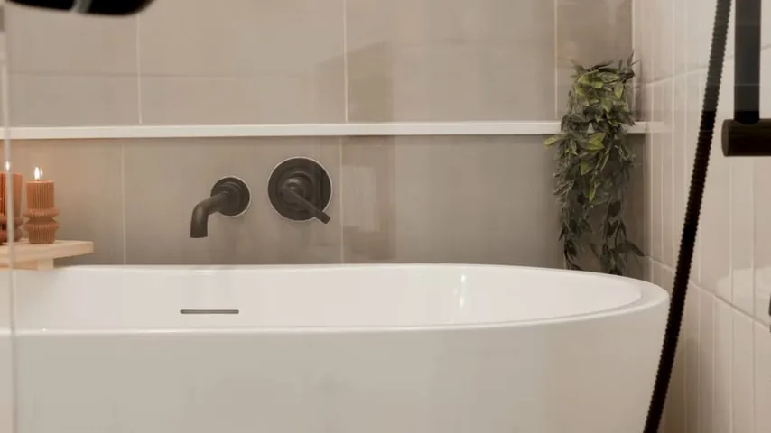 White bathtub with dark shower fixtures, documented during bathroom remodel plumbing checklist service in the Chapel Hill area