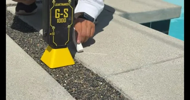 A technician working on pool leak detector scanning deck edge during a signs you need repiping call near Chapel Hill