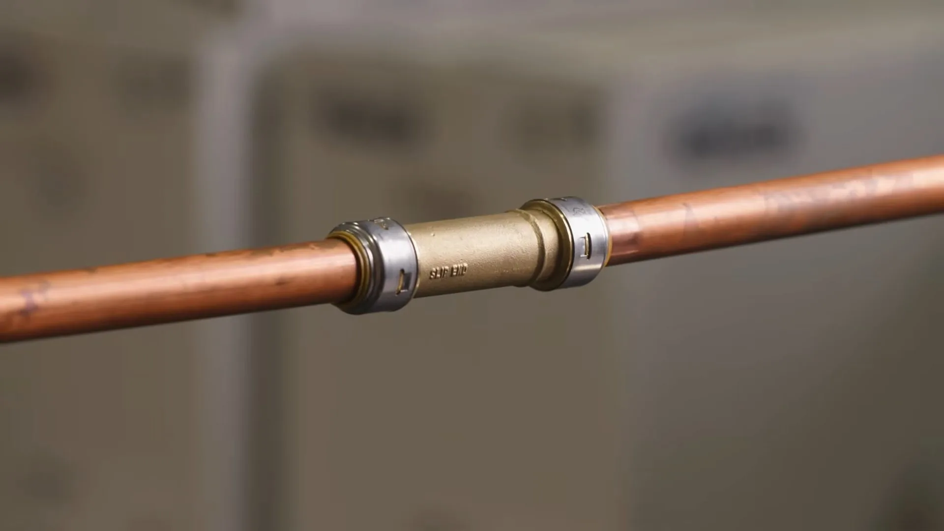 A technician working on repaired copper pipe with metal coupling during a sump pump battery backup call near Chapel Hill