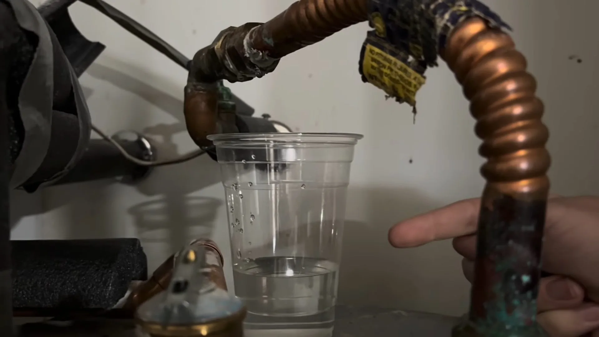 Close view of pouring water into heater hose connection handled during a tankless vs. tank water heaters appointment