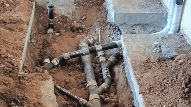 A technician working on residential water heater and pipe service during a water heater lifespan guide call near Chapel Hill