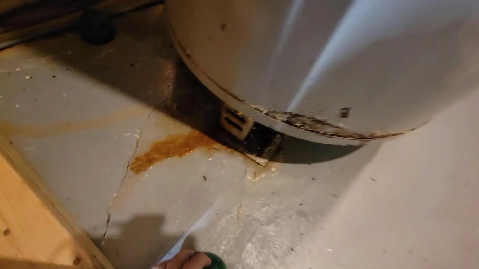 Rust stain below old water heater photographed on site during water heater lifespan guide work